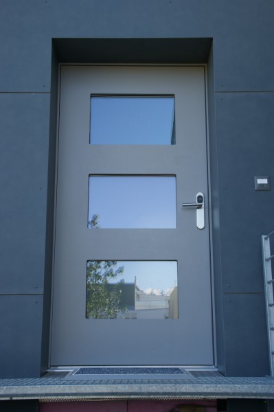 Graue Eingangstüre mit drei kleinen Fenstern, eingebaut von der Firma Weidmann AG in Möhlin.