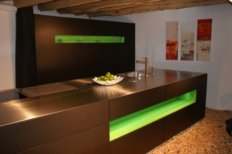 Schwarze Küche in modernem Design mit Chromstahlabdeckung und grünen Details. Ihre Küchenwünsche, erfüllt von der Firma Weidmann AG in Möhlin.
