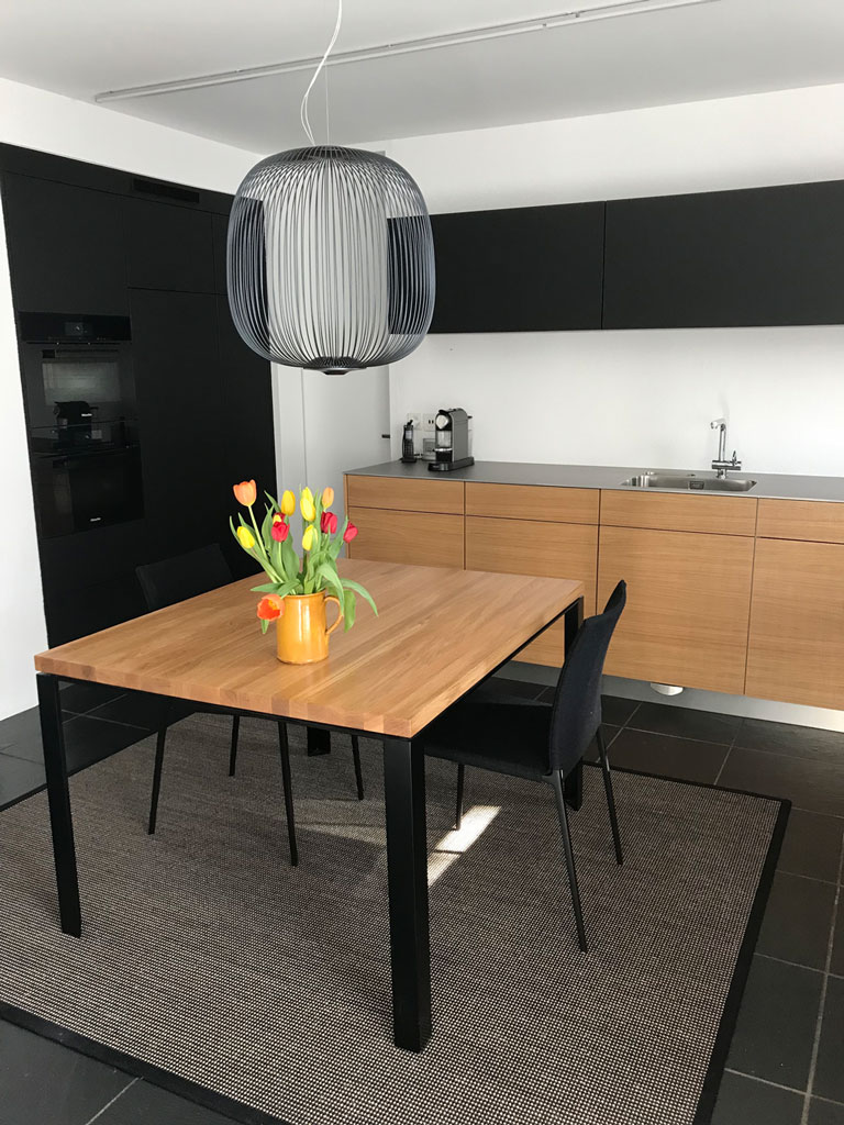 Schöne Holzküche mit schwarzer Schrankwand. Die Firma Weidmann AG in Möhlin baut Ihre Traumküche.